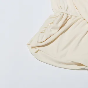 Gros plan détaillé montrant le côté plissé élégant et la texture du tissu de ce chemisier