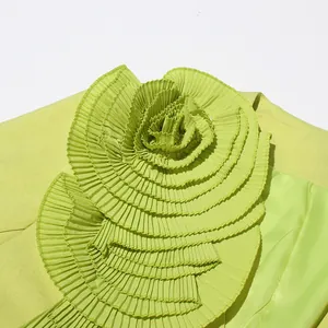 Macro detail of a lime green women's blazer with a large 3D pleated fabric flower