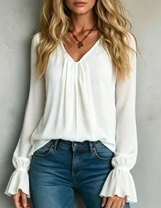 Detailed shot of white V-neck blouse with elegant front pleats and flared cuffs.