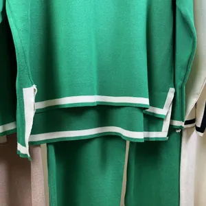 Detailed view of green knitted two-piece set featuring white stripes and side slit hem