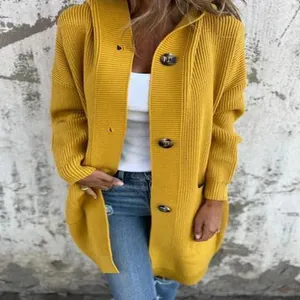 Dettaglio di un cardigan in maglia giallo senape con cappuccio e bottoni neri.
