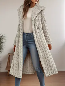 Close-up detail of a long light gray hooded fuzzy coat for women in a home setting