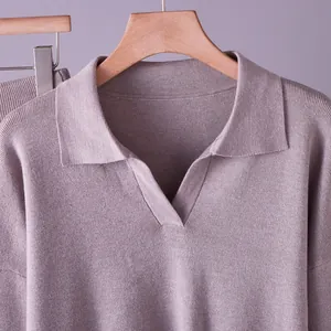 Close-up of a mauve knitted polo sweater featuring a V-neck and soft textured fabric