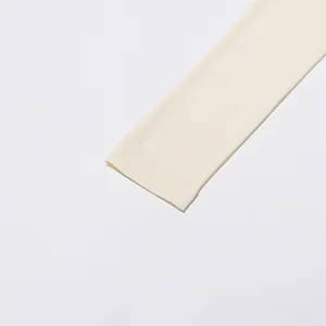 Gros plan montrant les coutures fines du poignet d'une blouse minimaliste de couleur crème
