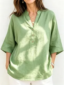 Detalle de camisa de lino verde transpirable con escote en V y tapeta con botones vista
