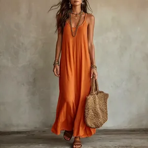 Robe longue orange bohème pour les vacances à la plage avec un sac en paille tissé
