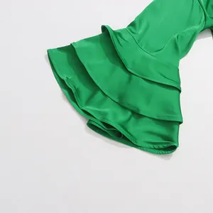 Detailed view of the layered ruffled sleeve on this elegant green satin blouse.