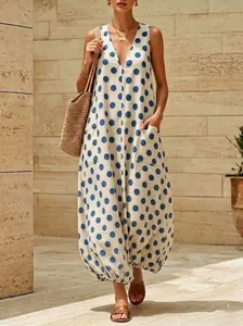 Dettaglio dell'abito lungo retrò a pois con scollo a V, tasche e orlo a palloncino.