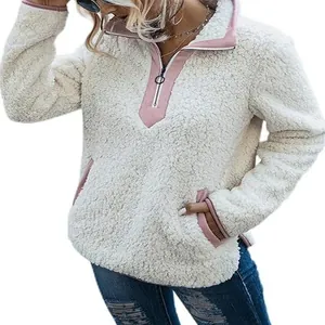 Sweat-shirt en polaire blanche avec détails roses zippés et poches pour l'automne-hiver.