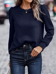 Detailed macro shot of navy blue quilted sweatshirt featuring elegant puff sleeves design