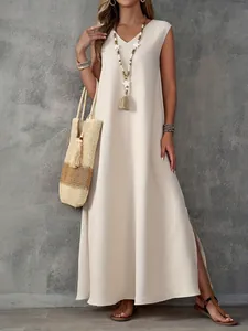 Detail van een elegante beige mouwloze maxi-jurk met V-hals en zijsplit voor dames