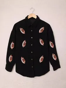 Damen-Hemdjacke aus schwarzem Cord mit Pailletten-Football-Mustern auf einem Kleiderbügel.