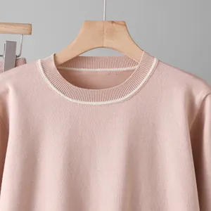 Close-up detail of a pink women's knit sweater with contrast white stripe on the collar
