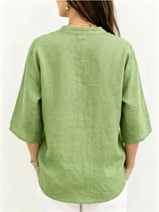 Vista trasera de una blusa de lino verde holgada para mujer con mangas 3/4 y textura