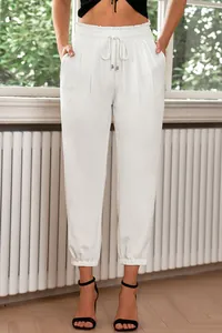 Close-up of white high-waisted drawstring trousers with elasticated ankle cuffs