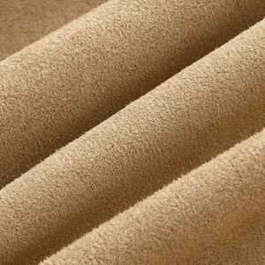 Detailed macro shot of soft tan suede-like fabric texture for vintage style women's jacket detail