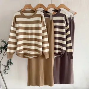 Close-up of elegant knitted two-piece set featuring striped sweater and high waist skirt