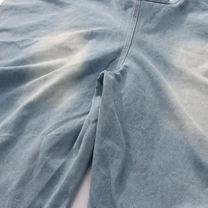 Détail d'un jean rétro bleu clair à taille haute avec délavage vintage et finition usée