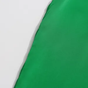 Macro view showing the smooth green satin fabric texture of a French style blouse