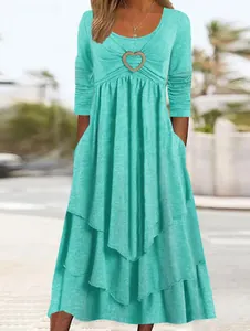 Detail of mint green long sleeve tiered cake dress featuring a golden heart buckle