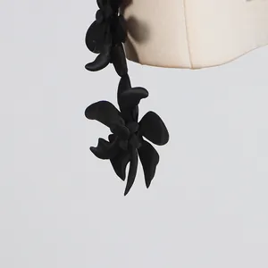 Macro view showing the 3D black fabric flower detail on a stylish sleeveless top
