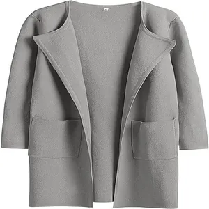 Dettaglio ravvicinato di un cappotto grigio in lana con revers e tasche frontali.