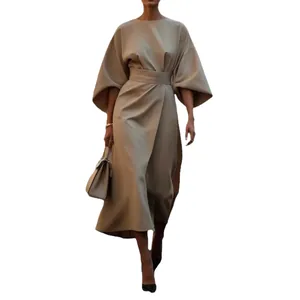 Robe longue élégante à taille ajustée et manches chauve-souris, couleur beige unie.