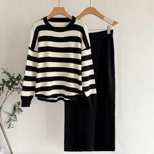 Detail showing the contrast of a striped knit top and a smooth black midi skirt set