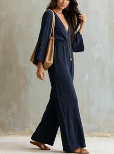 Bohemian navy blue V-neck wide-leg jumpsuit with long sleeves and pleated fabric texture