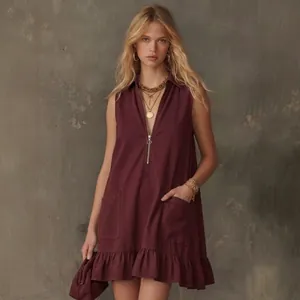 Full length detail of sleeveless burgundy mini dress featuring front pockets and ruffles