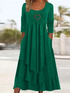 Detail view of women's casual emerald green tiered cake dress with heart buckle