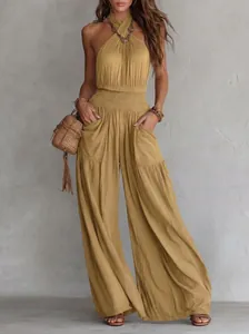 Detail view of a mustard yellow bohemian backless wide-leg jumpsuit with pockets