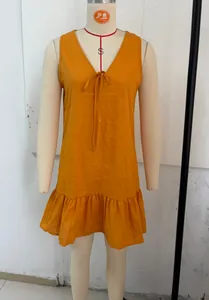 Close-up view of the orange V-neck sleeveless dress with bow tie and ruffled hem