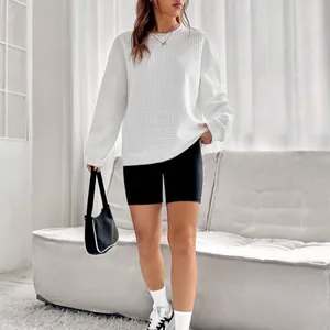 Vue détaillée d'un sweat-shirt blanc en maille gaufrée à col rond pour femme en intérieur