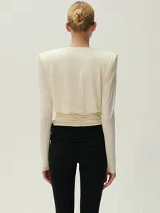 Vue arrière d'un haut crème minimaliste à épaules rembourrées et taille froncée.