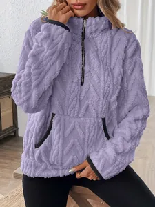 Détail d'un sweat à capuche en polaire violette à demi-zip avec texture jacquard chic.