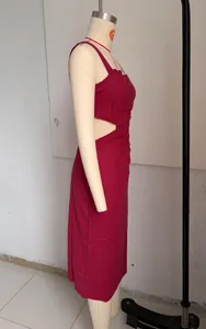Dettaglio dell'abito midi bordeaux con ritagli laterali e drappeggio elegante.