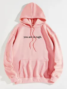 Detail view of pink hoodie featuring 'you are enough' print and kangaroo pocket