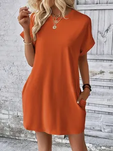 Close-up of a loose orange crewneck mini dress with functional side pockets.