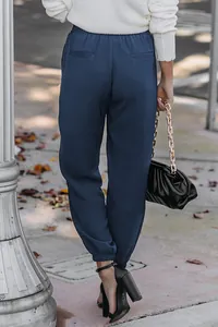Back view of women's high-waisted navy blue joggers with elastic cuffs and pockets.