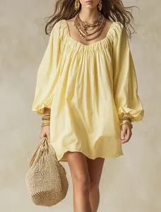 Robe courte bohème ample à manches lanternes jaune pâle avec détails texturés.