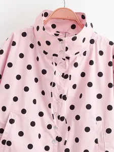 Detailed view of pink polka dot jacket featuring stand collar and drawstring details