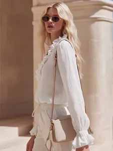 Detailed view of an elegant white linen ruffled blouse with romantic French vintage vibes