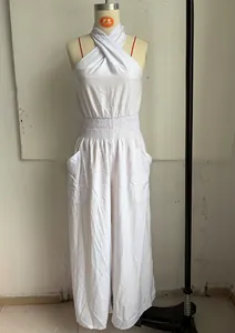 Detailed view of a white sleeveless wide-leg jumpsuit with a smocked waist on a mannequin.