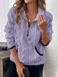 Détail d'un sweat en polaire lilas à demi-zip avec motif texturé et poches frontales
