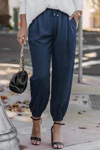 Close-up of stylish navy blue high-waisted drawstring joggers with cuffed elastic ankles.