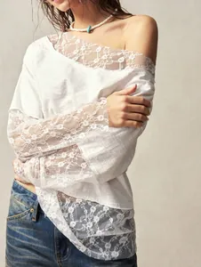 Close-up of white bohemian off-shoulder top showing delicate lace trim and sleeves