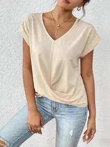 Detail view of a beige V-neck short sleeve T-shirt with twisted hem on a model