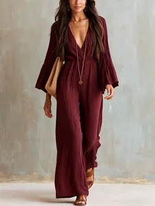 Detail view of the deep V-neck and crinkled fabric texture on this burgundy jumpsuit