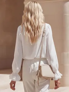 Detailed back view of an elegant French style white linen blouse with ruffle cuffs